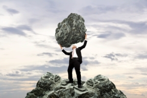 Holding up a boulder representing a difficult client